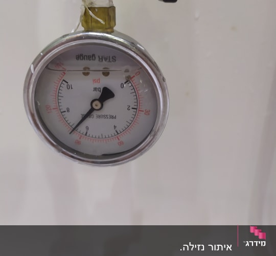 מד לחץ מחובר לצינור עם חיבורים